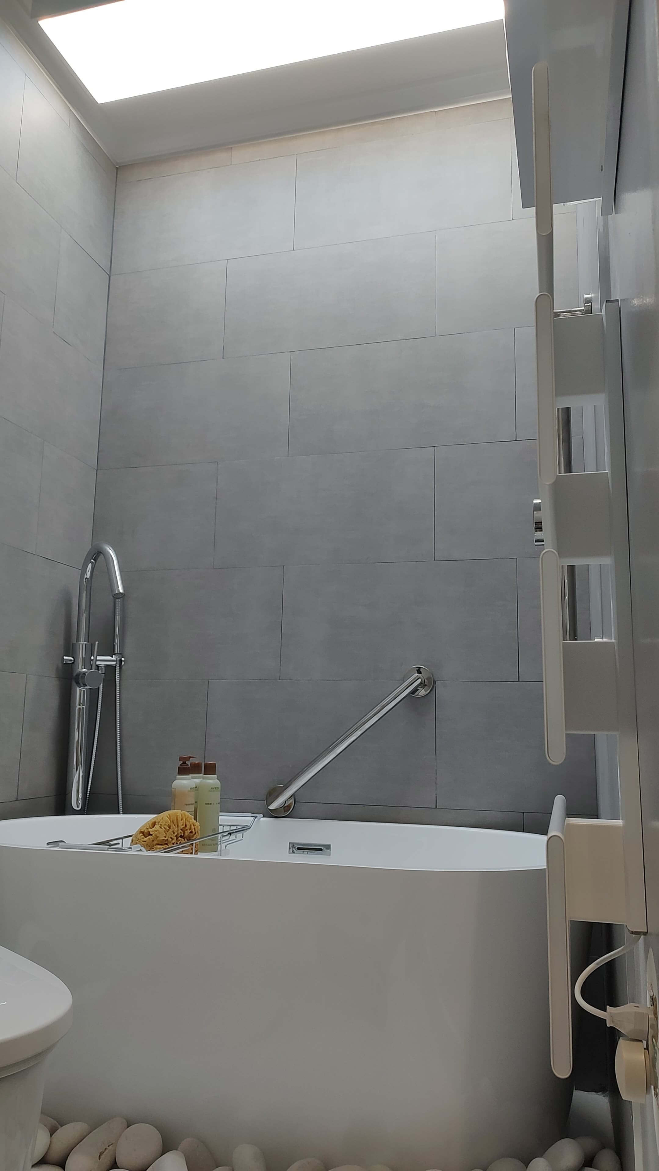 Freestanding soaking tub with heated towel rack and grab bar