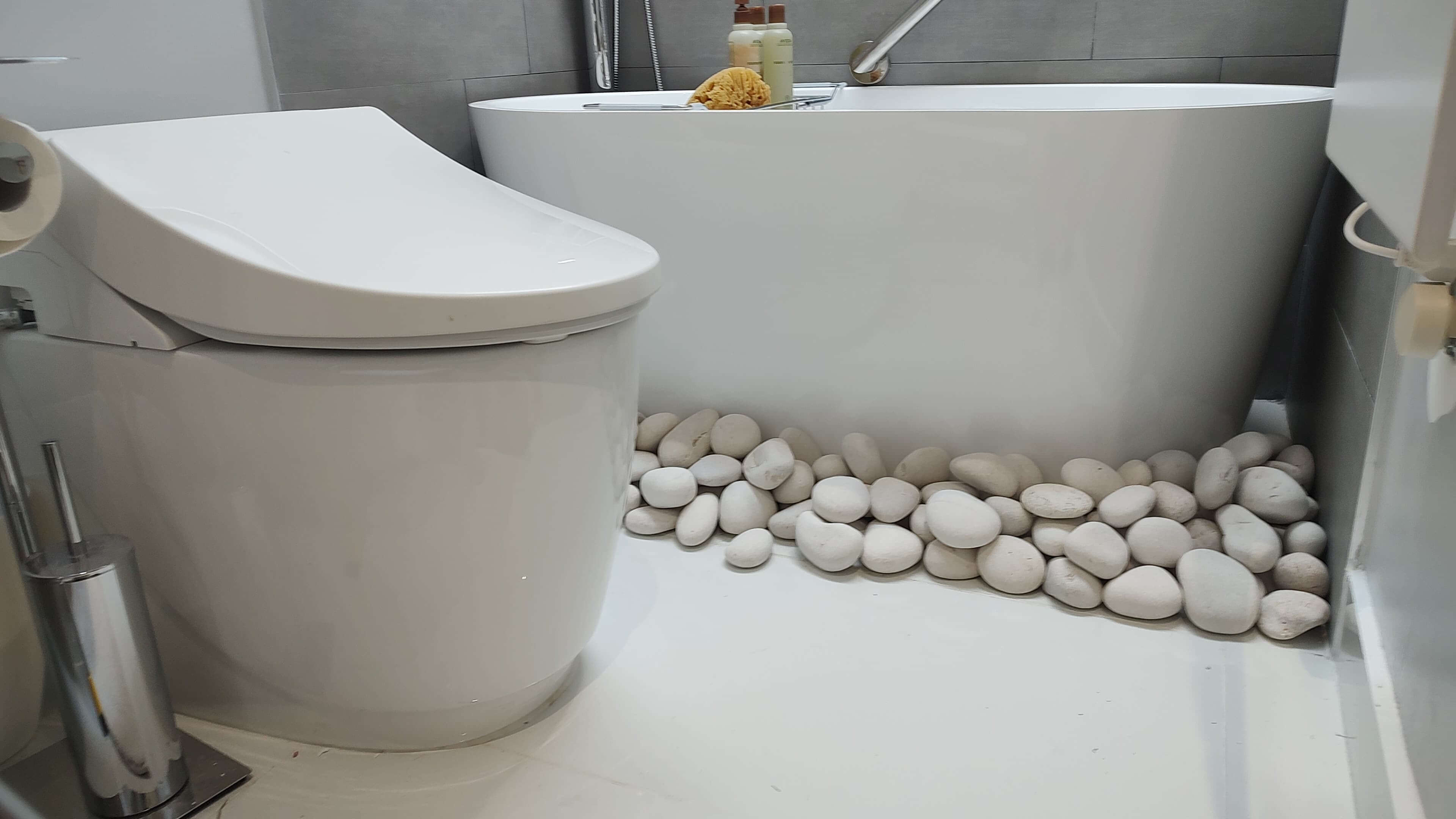 Bathroom remodel with smart toilet and river-stone accent
