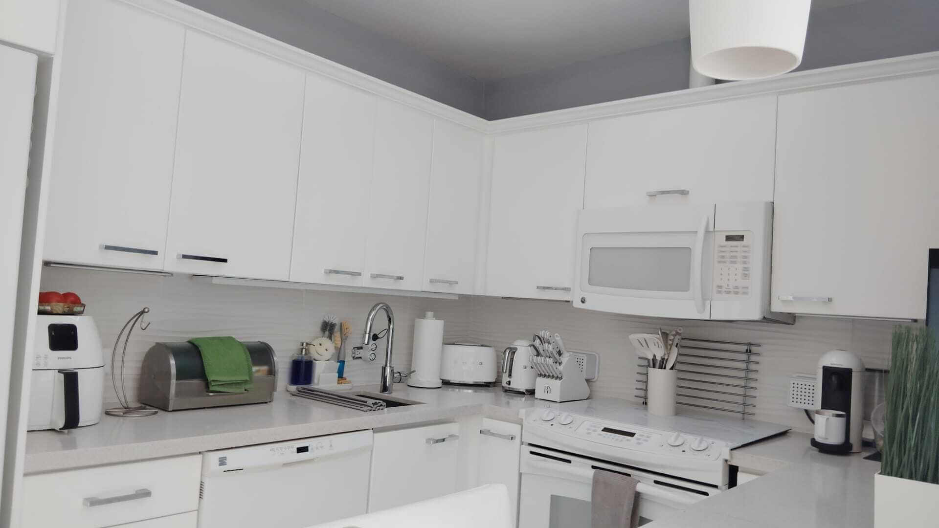 White kitchen cabinets and refrigerator after remodel